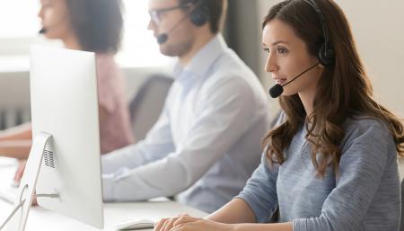 Image of a female customer service agent wearing a headset while speaking to a client
