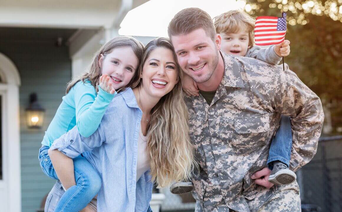 Excited soldier happily reunited with his young family.