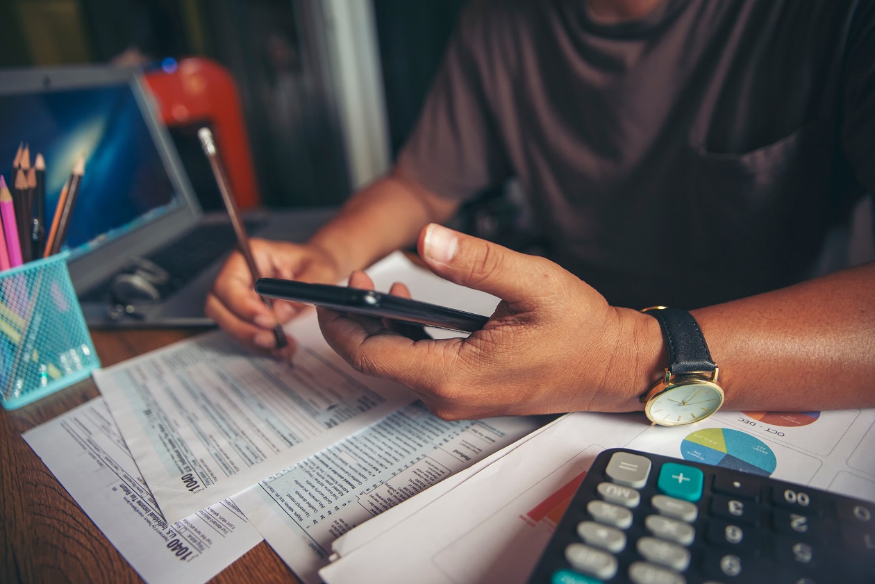 Person holding the mobile device while doing their taxes.
