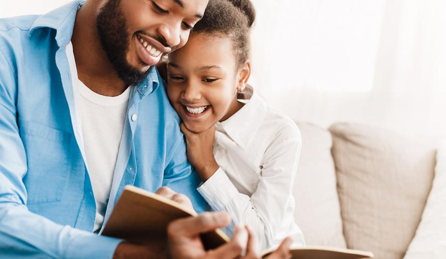 Image of a father and daughter reading a book. 